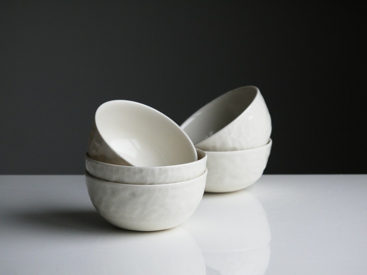 A stack of oatmeal glazed stoneware plates and bowls