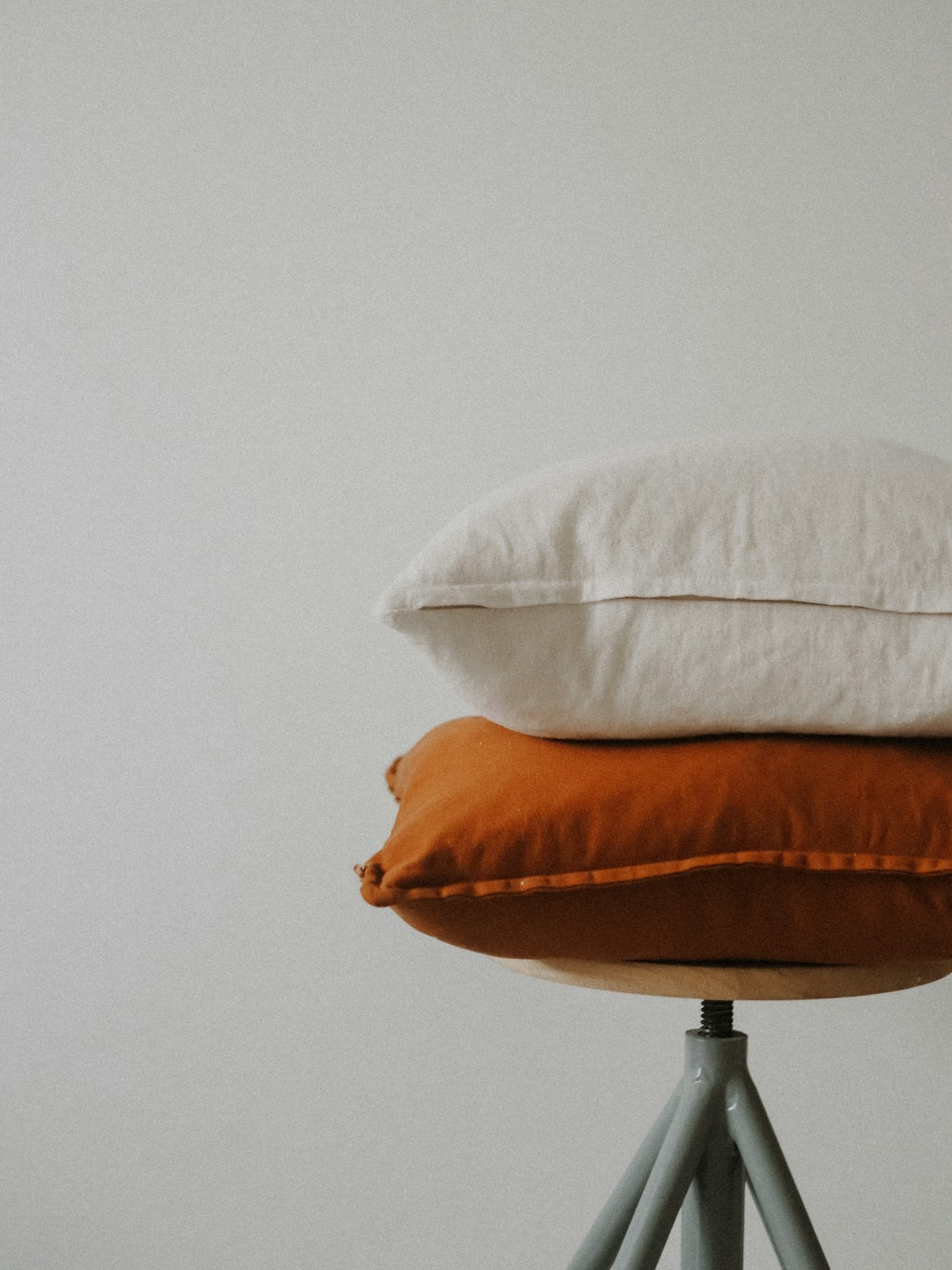 A square clay coloured linen cushion