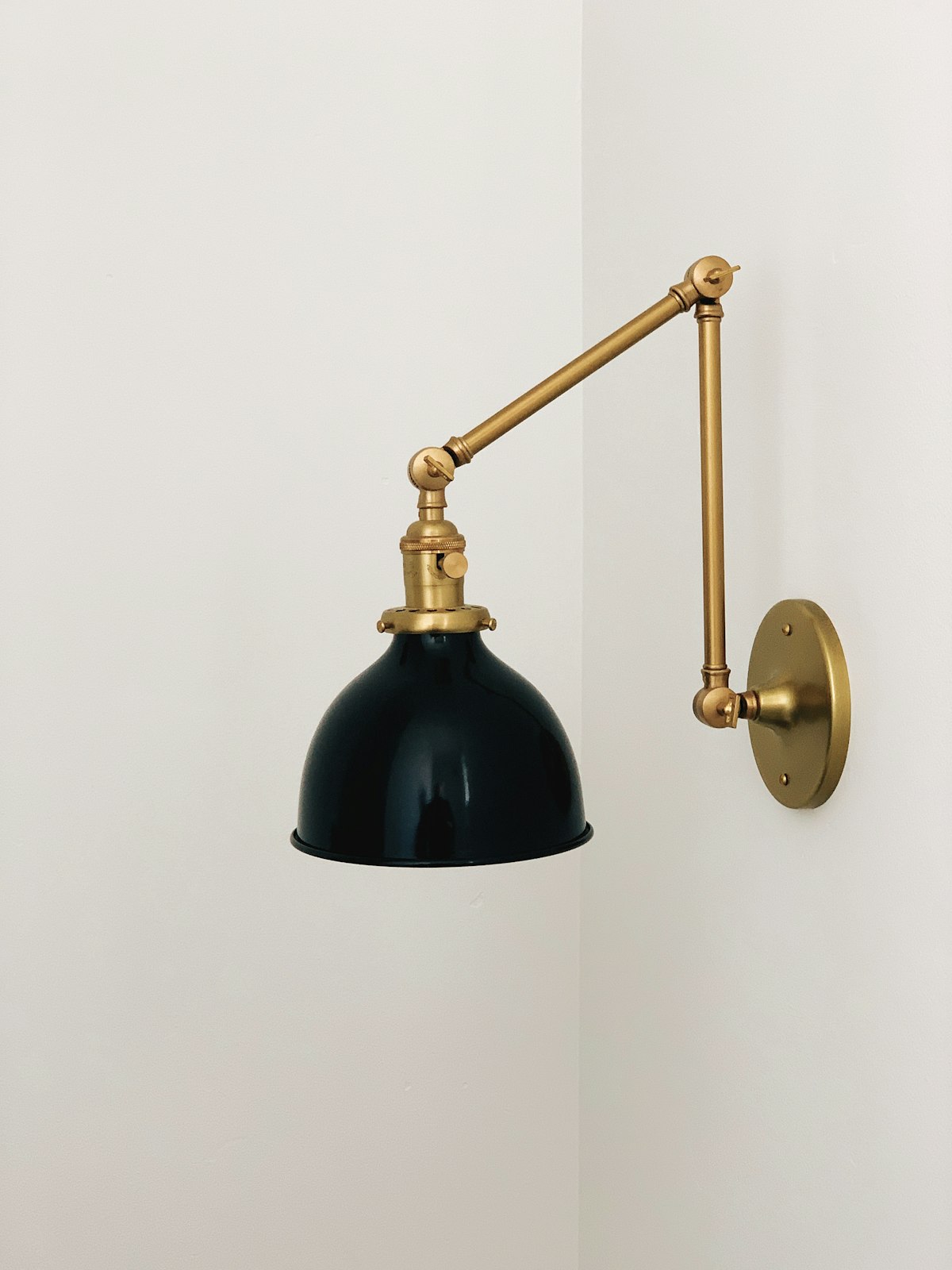 A brushed brass swing arm wall light